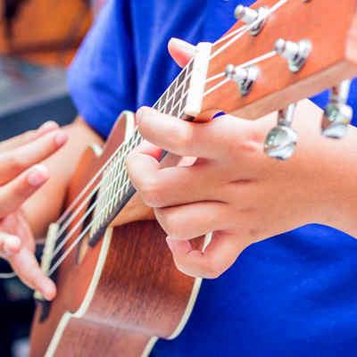Ukelele lessons. Close up of hands playing a ukelele.